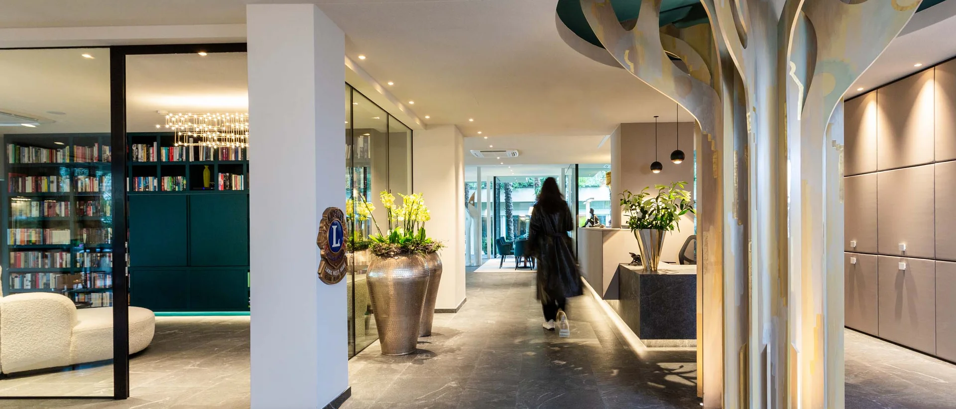 Moderner Hotellobbyflur mit Baumskulptur und Person im Hintergrund