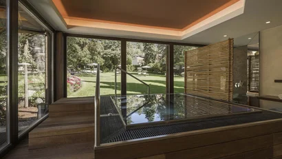 Innenraum mit Holzwannenbad und Blick auf den Garten