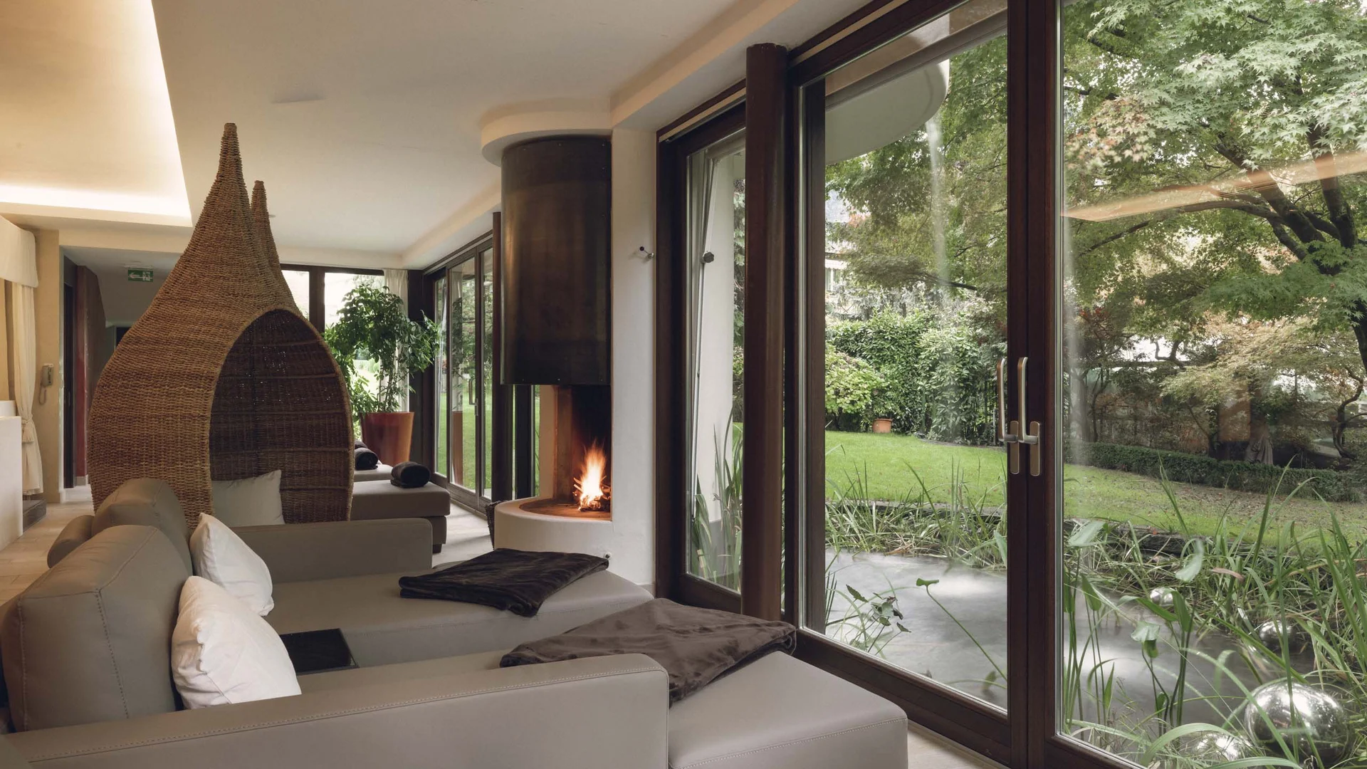 Modern lounge with fireplace and large windows overlooking garden