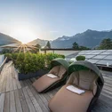 Lounge chairs on terrace with mountain view at sunset