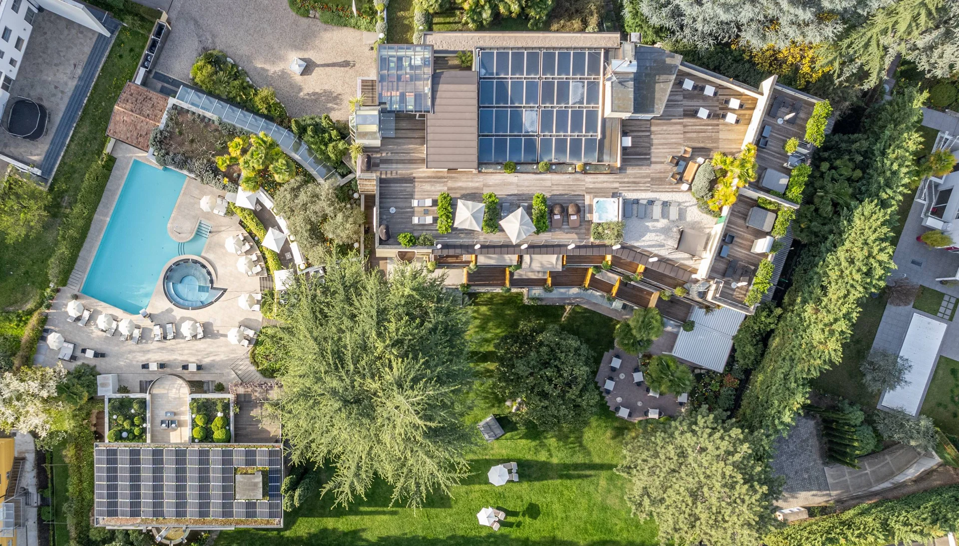 Luftaufnahme eines Hauses mit Solarzellen, Pool und Garten