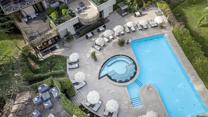 Vogelperspektive eines Swimmingpools mit Liegestühlen und Sonnenschirmen