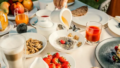 Frühstückstisch mit Obst, Nüssen, Saft und Joghurt mit Honig