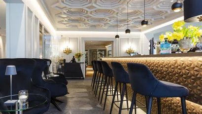 Elegante Hotelbar mit geometrischer Decke und modernen Sitzgelegenheiten