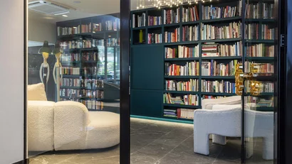 Moderner Leseraum mit Bücherregal und bequemen Sesseln