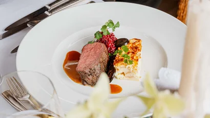 Table setting with served gourmet dish and serving cloche