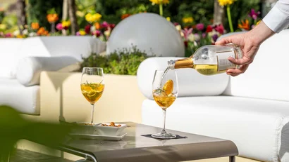 Ein Getränk mit Eis und Orangen wird an einem Tisch im Freien eingeschenkt